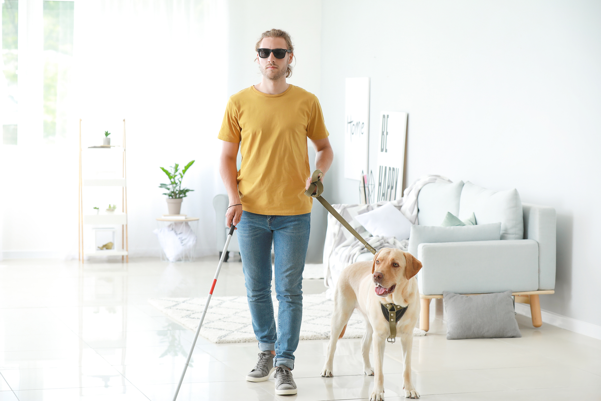 Blind young man with guide dog at home, Hampton Hampton property management