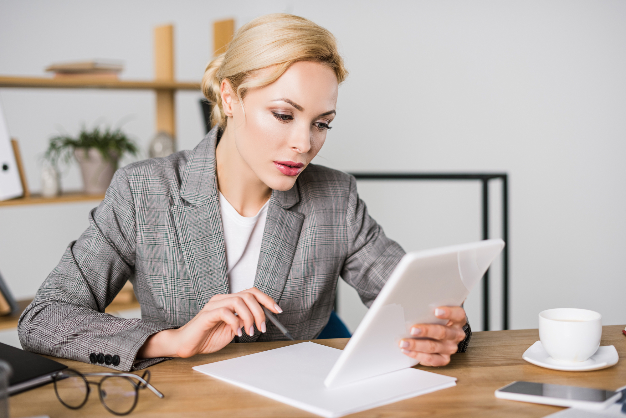 Portrait of focused businesswoman using tablet at workplace in office