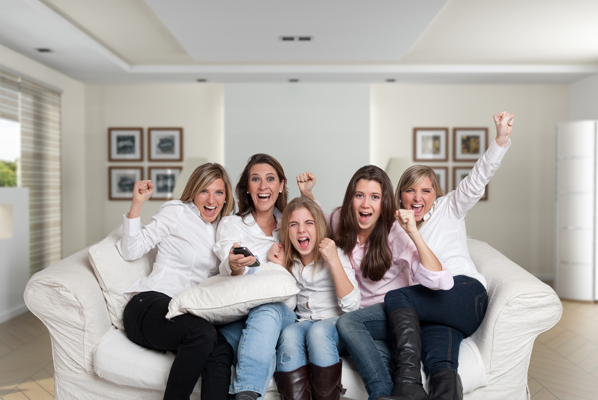 Women cheering on the sofa